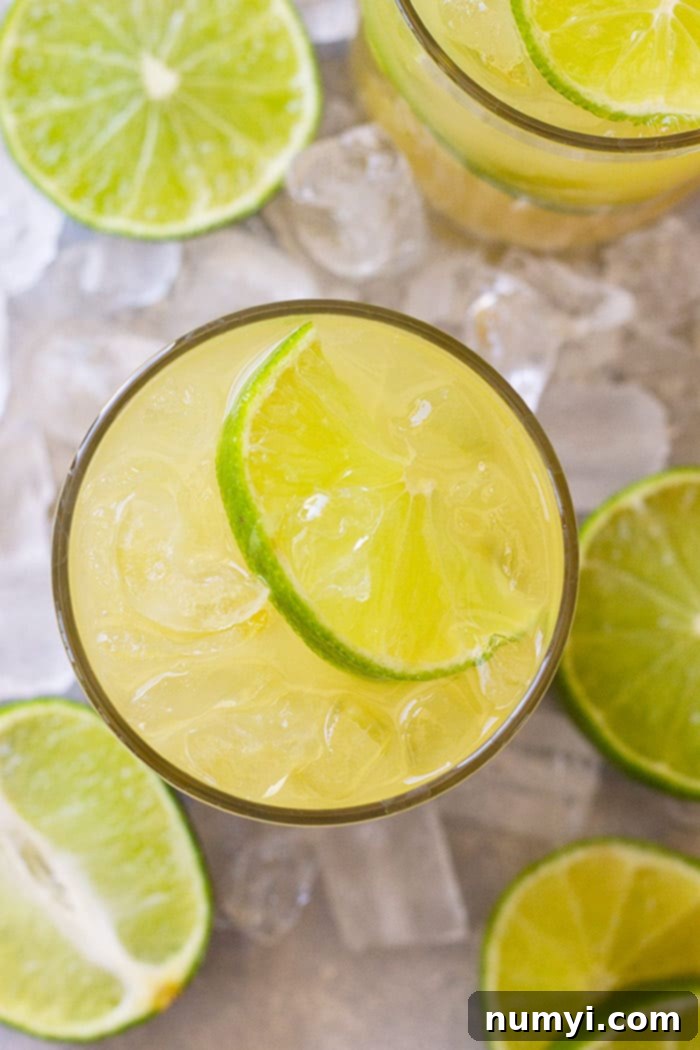 Top down view of classic margarita in a glass with a lime wedge and lots of ice.