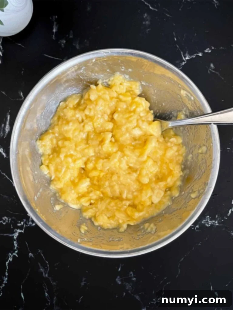 Melt-In-Your-Mouth Banana Bread Made Simple 3 Perfectly mashed ripe bananas in a metal bowl, ready for the banana bread recipe.
