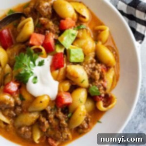 Creamy Cheesy Taco Pasta 6 top down picture of a bowl of taco pasta topped with taco toppings.