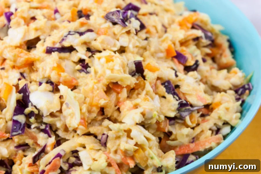 Large blue bowl filled with vibrant Tangy Southern Mustard Coleslaw, ready to be served.