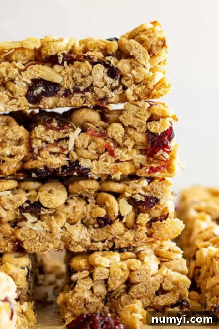 A close-up shot of a stack of Cheerio granola bars, showing their texture and the visible cranberries and almonds.
