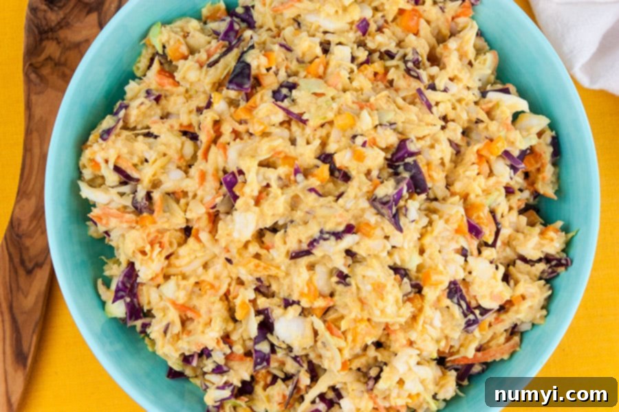 A vibrant blue bowl filled with fresh, Tangy Southern Mustard Coleslaw, ready to be served.