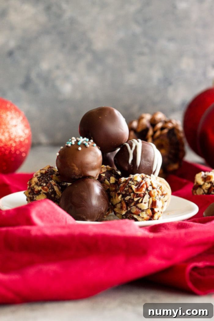Homemade Chocolate Truffles stacked on top of each other in a pyramid shape, with a light dusting of cocoa powder.