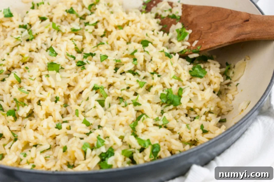 Cilantro lime rice in a gray skillet garnished with chopped cilantro, ready to be served.