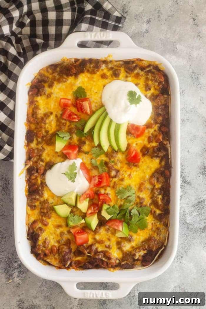 overhead shot of taco casserole topped with sour cream and veggies and cilantro