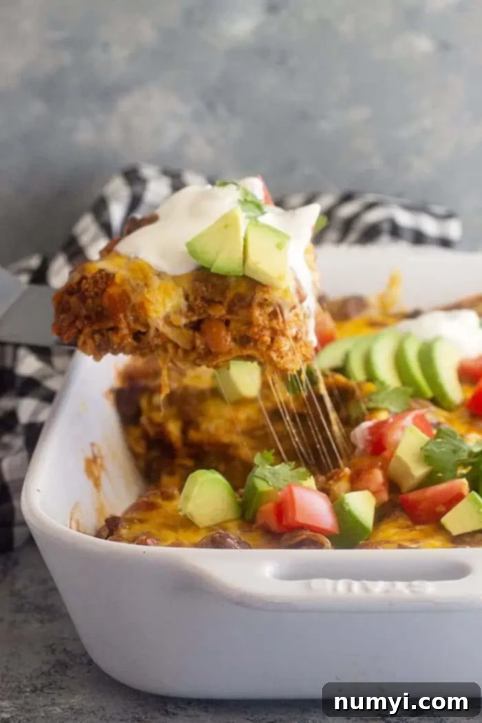 serving a slice of Mexican casserole with ground beef