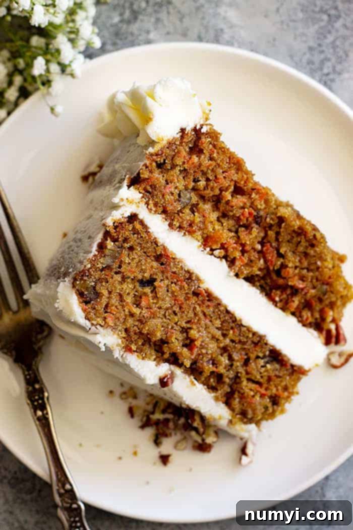 Simple carrot cake on a white plate, showcasing its moist texture and delicious cream cheese frosting.