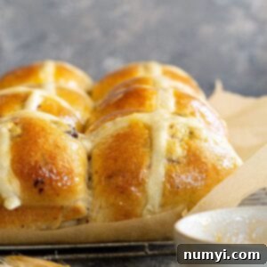 Close up of hot cross buns in a baking pan.
