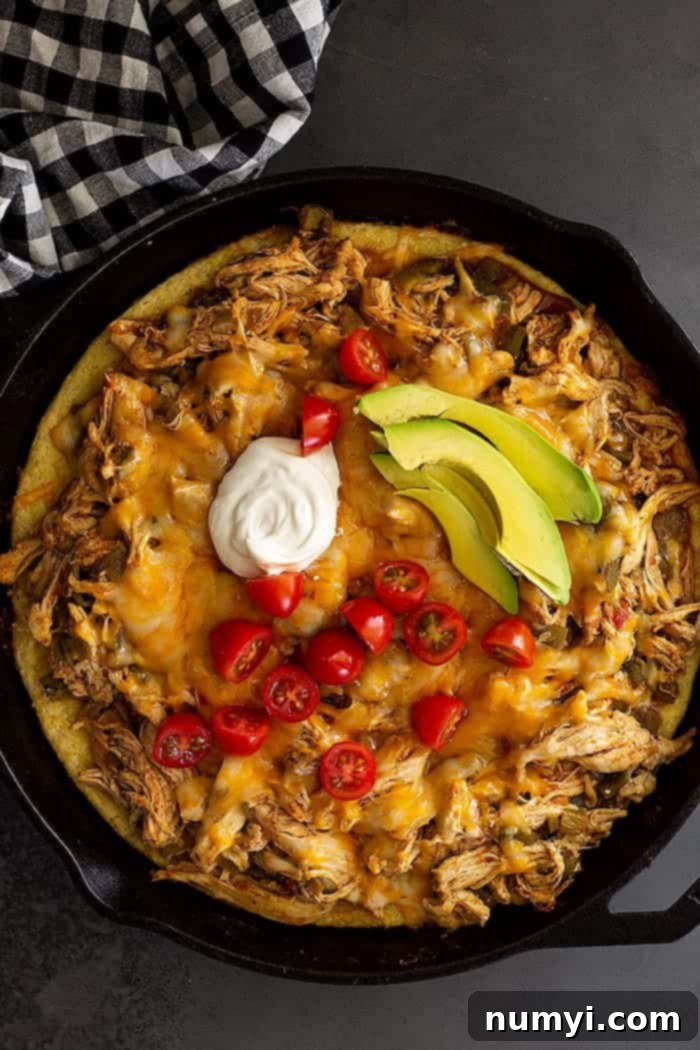 Fiesta Chicken Tamale Bake 2 overhead: chicken tamale pie baked with melted cheese and sour cream, tomatoes, and avocado on top