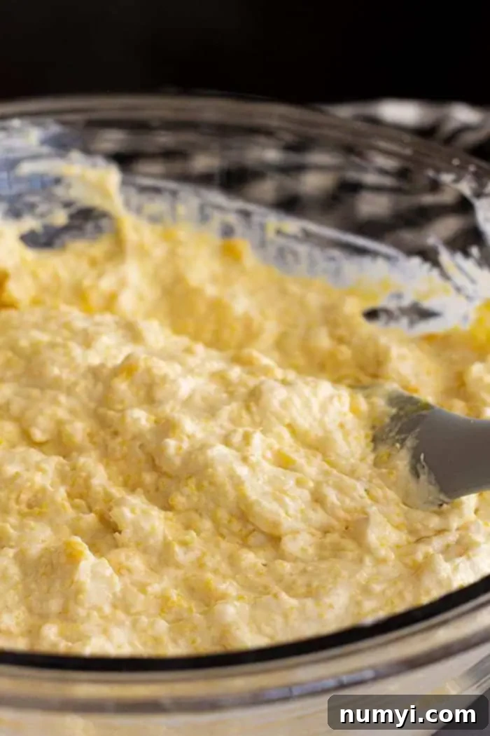 Fiesta Chicken Tamale Bake 5 closeup: cornbread base being mixed with a spatula
