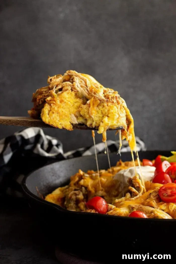 Fiesta Chicken Tamale Bake 10 side view: spoonful of tamale pie with chicken being served from the skillet