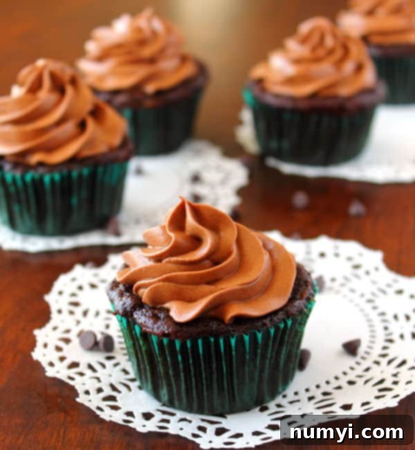 Decadent Chocolate Zucchini Cupcakes with Cream Cheese Frosting 2 Chocolate Zucchini Cupcakes with chocolate Cream Cheese Frosting sitting on white paper doilies