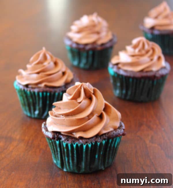 Decadent Chocolate Zucchini Cupcakes with Cream Cheese Frosting 3 Chocolate Zucchini Cupcakes with Cream Cheese Frosting on a wood table