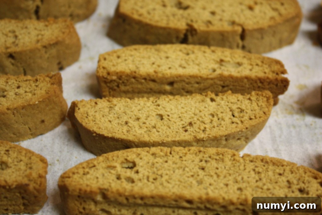 Sliced Espresso Biscotti arranged on a parchment paper lined baking sheet for the second bake.