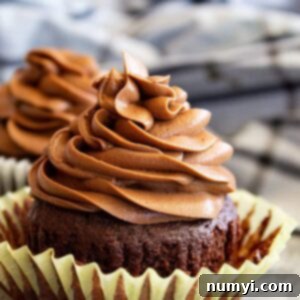 Frosting piped in a swirl on top of a chocolate cupcake.