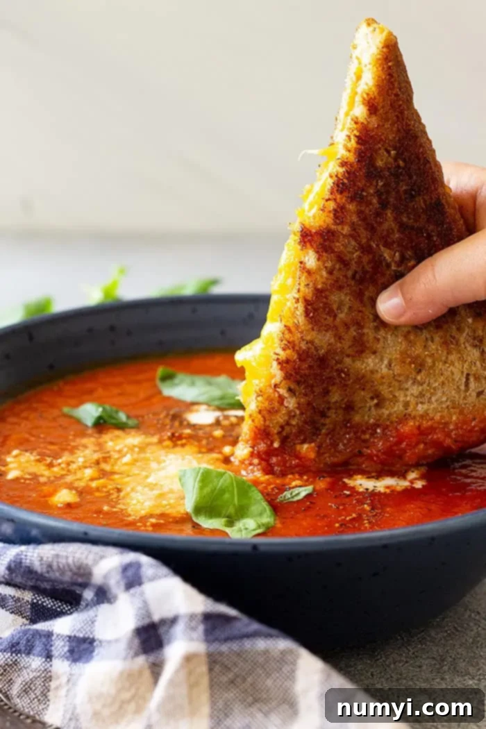 Dipping a grilled cheese into a bowl of hot soup.