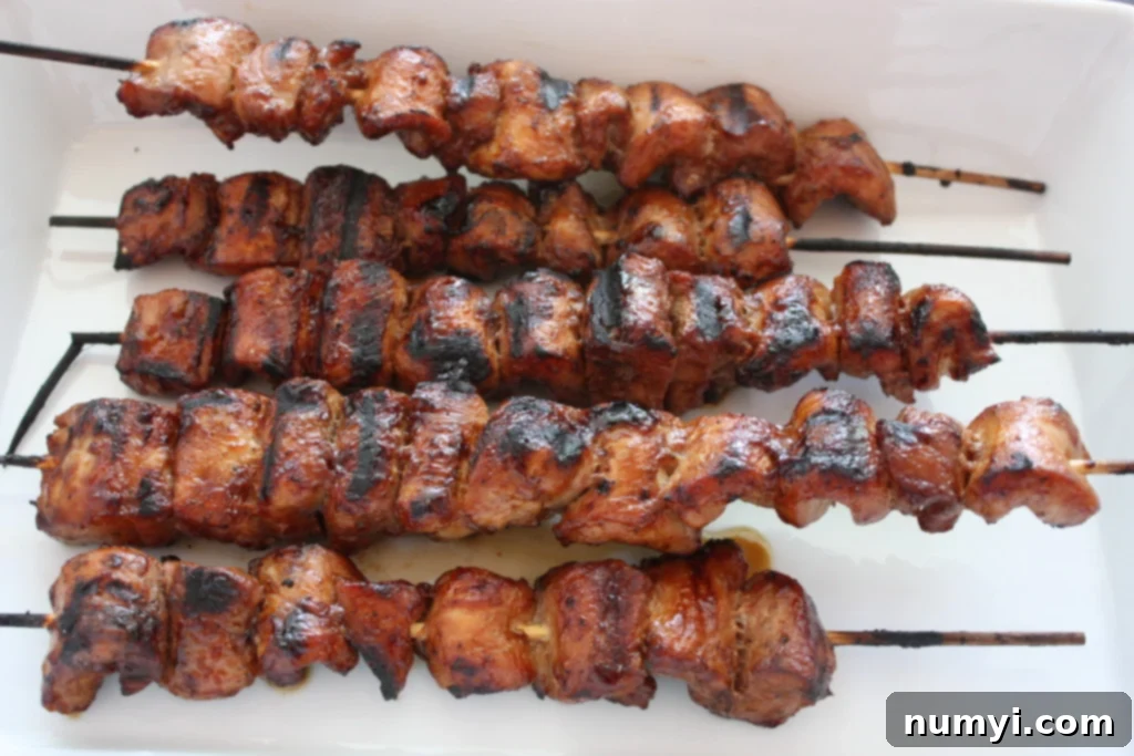 Classic Filipino Pork BBQ Skewers 2 Filipino Pork Kebabs (Pinoy) skewers on a white plate.