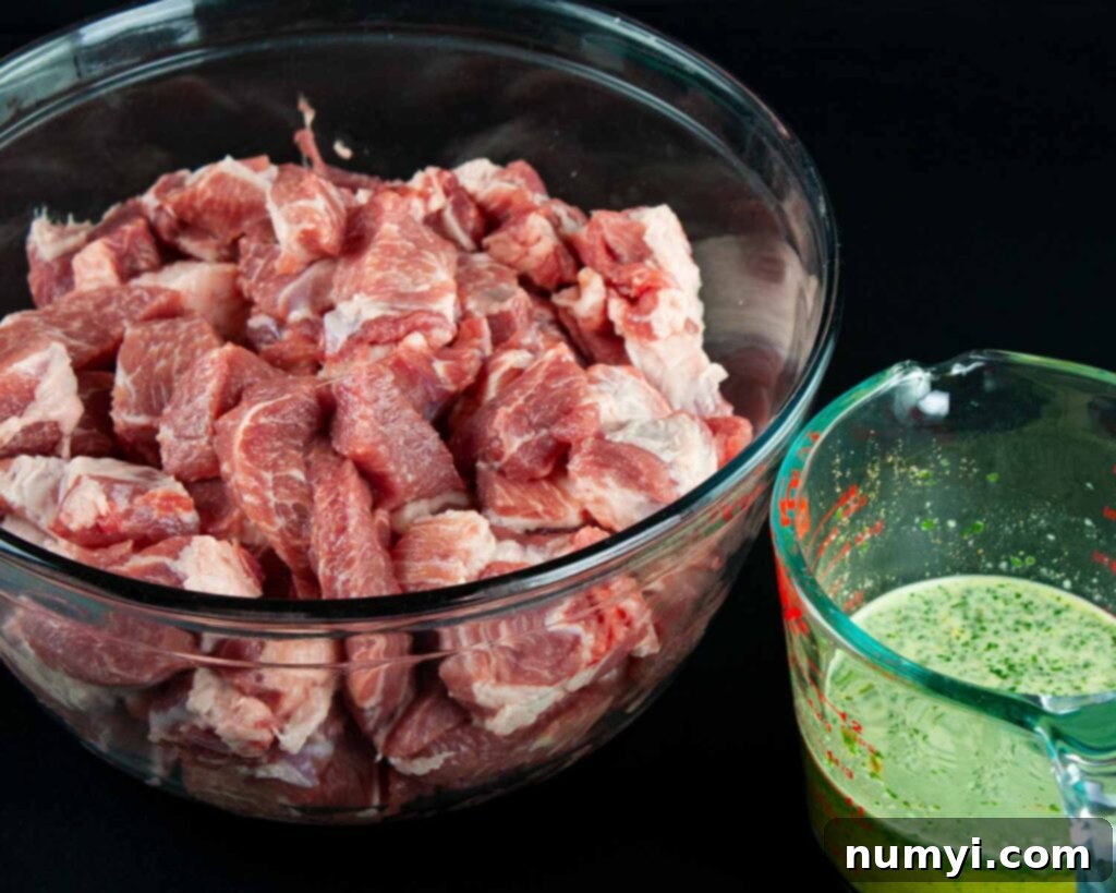 Freshly cubed pork ready for marination on a cutting board.