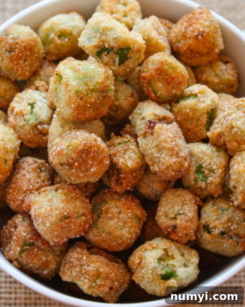 Buttermilk-Kissed Golden Okra: A Southern Crunch 5 A pristine white bowl filled to the brim with a generous serving of crispy, golden-brown fried okra.