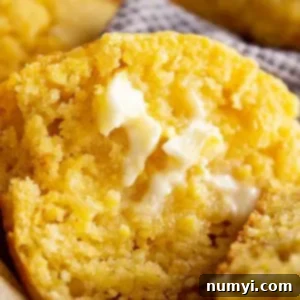 Golden Cornbread Delights 8 A close up of a muffin cut in half with butter melting on it.