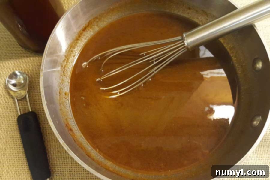 Pumpkin spice syrup simmering gently in a saucepan, filling the kitchen with a delightful aroma.
