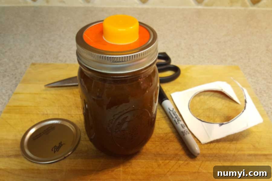 A mason jar filled with pumpkin spice syrup, cleverly fitted with a repurposed juice carton spout under the lid ring for easy pouring.