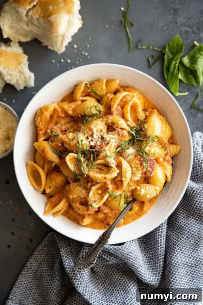 Easy Homemade Vodka Sauce 2 overhead shot of a bowl of pasta with homemade vodka sauce, garnished generously with fresh herbs and grated Parmesan cheese