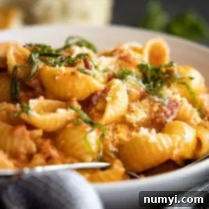 Easy Homemade Vodka Sauce 7 Close side angle of the sauce and pasta in a white bowl. Garnished with basil and parmesan cheese.