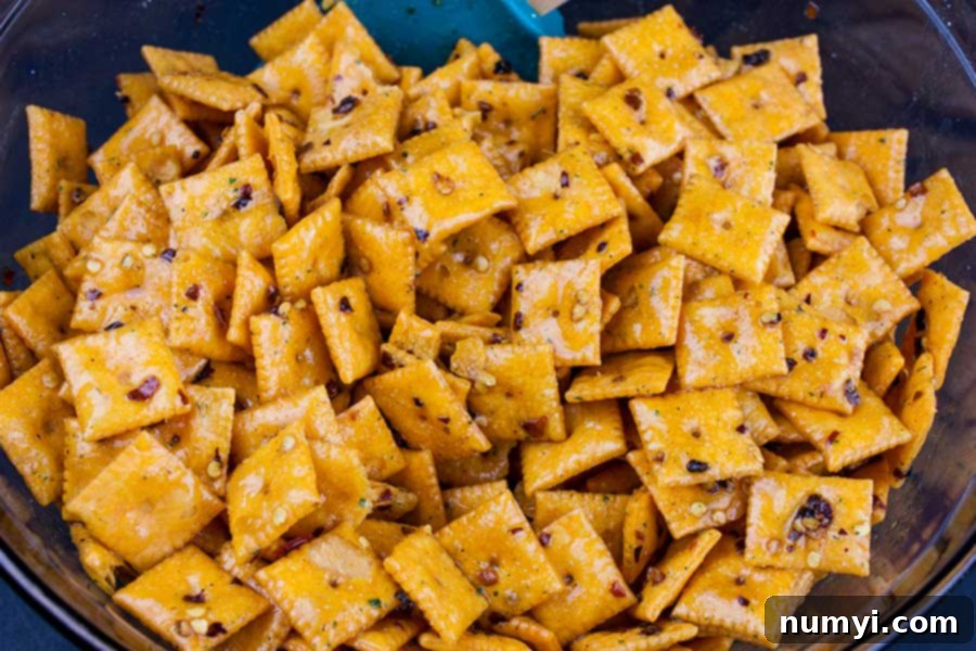 Exploding Cheese Bites 4 Firecracker Cheez-Itz - crackers in a large glass bowl with seasoning mixture poured over