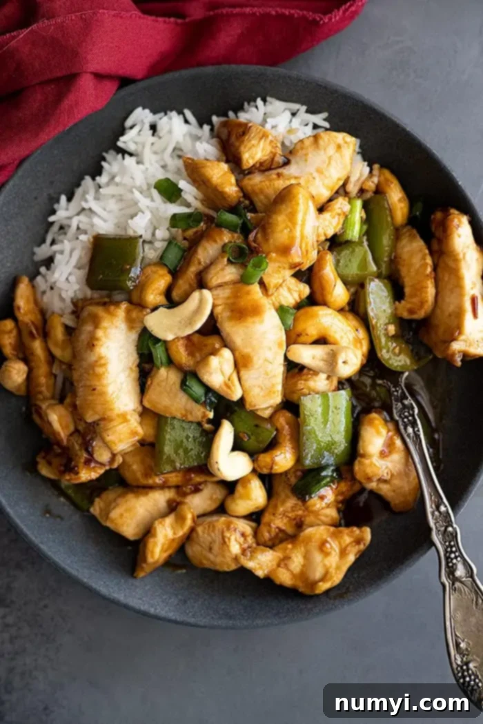 Overhead view of stirfry on a plate with white rice. Red napkin off to the side. 