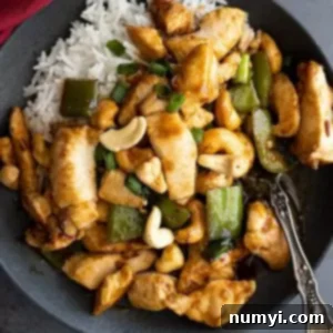 Overhead view of stirfry on a plate with white rice. Red napkin off to the side.