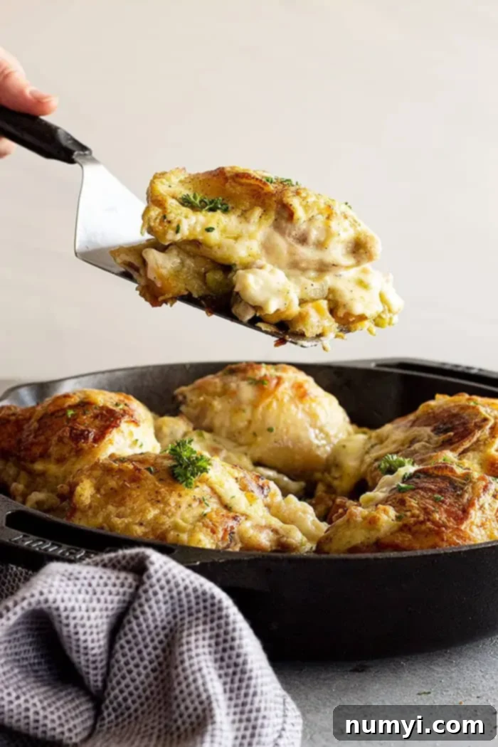Comforting Chicken and Stuffing Bake 5 side view: a spatula lifting a portion of the stuffing and chicken casserole out of the pan ready to serve onto a plate