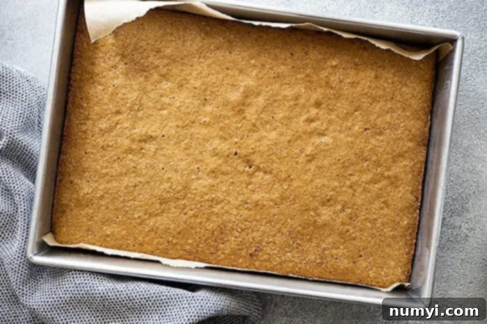 Hearty Spiced Oatmeal Cake 6 An overhead shot of the baked Old Fashioned Oatmeal Cake, fresh from the oven, with its warm, golden surface ready to receive the irresistible caramelized coconut nut topping.