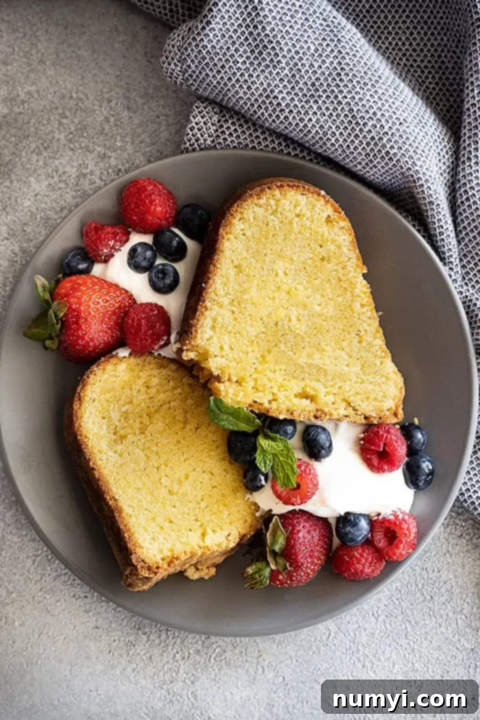 The Quintessential Pound Cake 2 Overhead view of two slices of moist, vanilla pound cake with a side of freshly whipped cream and vibrant fresh berries.