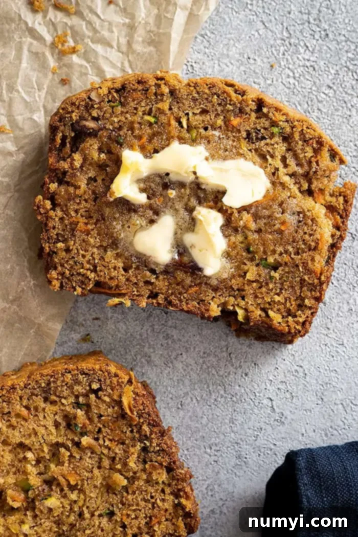 Wholesome Zucchini Carrot Loaf 5 overhead: a slice of zucchini and carrot bread with a pat of butter melting