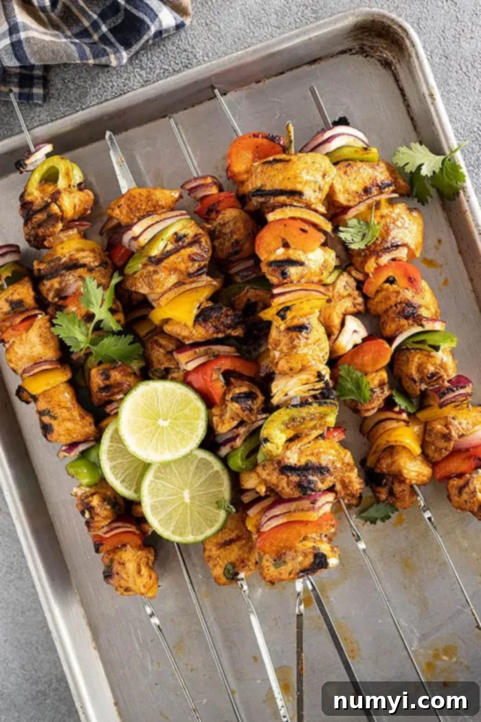 A pan filled with succulent grilled chicken fajita kebabs, garnished with fresh lime slices and bright cilantro. 