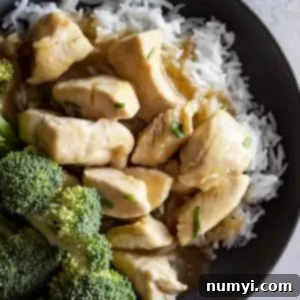 Overhead view of chinese lemon chicken in a bowl over white rice and a side of steamed broccoli.
