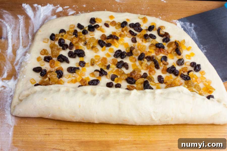 Simple Italian Christmas Panettone 13 Panettone dough rolled out into a rectangle, with soaked candied fruit sprinkled evenly across it, ready for rolling.