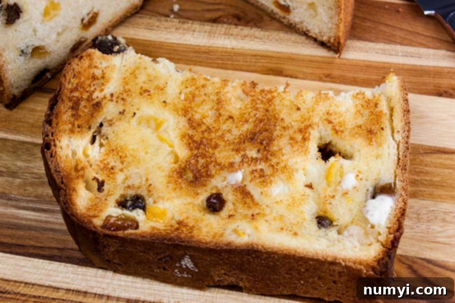 Simple Italian Christmas Panettone 3 A perfectly toasted slice of Panettone, lightly buttered, resting on a wooden surface.