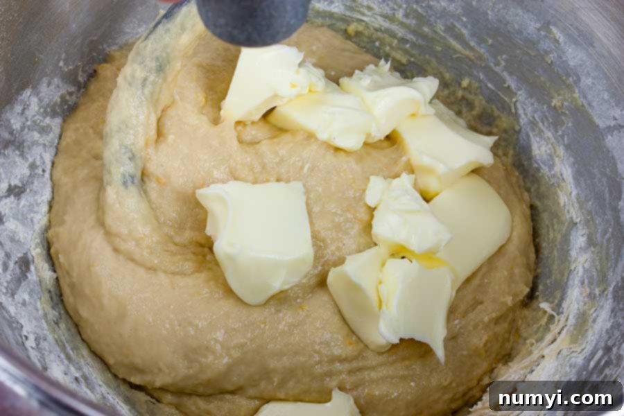 Simple Italian Christmas Panettone 7 Softened butter being incorporated into the developing panettone dough in a stand mixer.