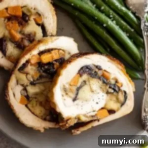Sweet Potato Stuffed Turkey Roulade 7 Close-up of a perfectly baked and sliced Sweet Potato and Stuffing Turkey Roulade, showing the golden-brown skin and the delicious filling.