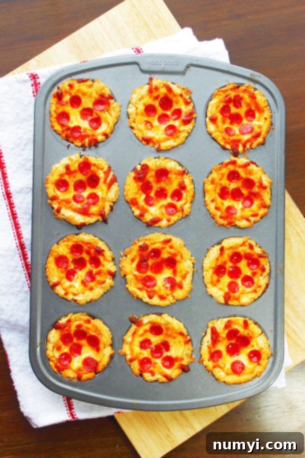 Mini Deep Dish Pizzas in a muffin tin with pepperoni on top, ready to be served.