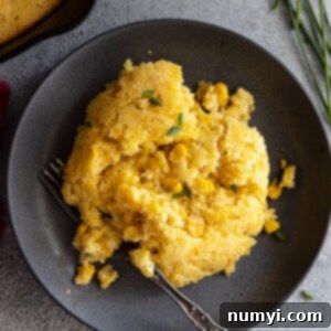 A slice of warm cornbread casserole on a plate.