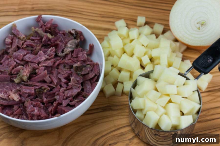 Closeup of ingredients for Corned Beef Hash: chopped corned beef, diced potatoes, and onions in bowls, ready for cooking.