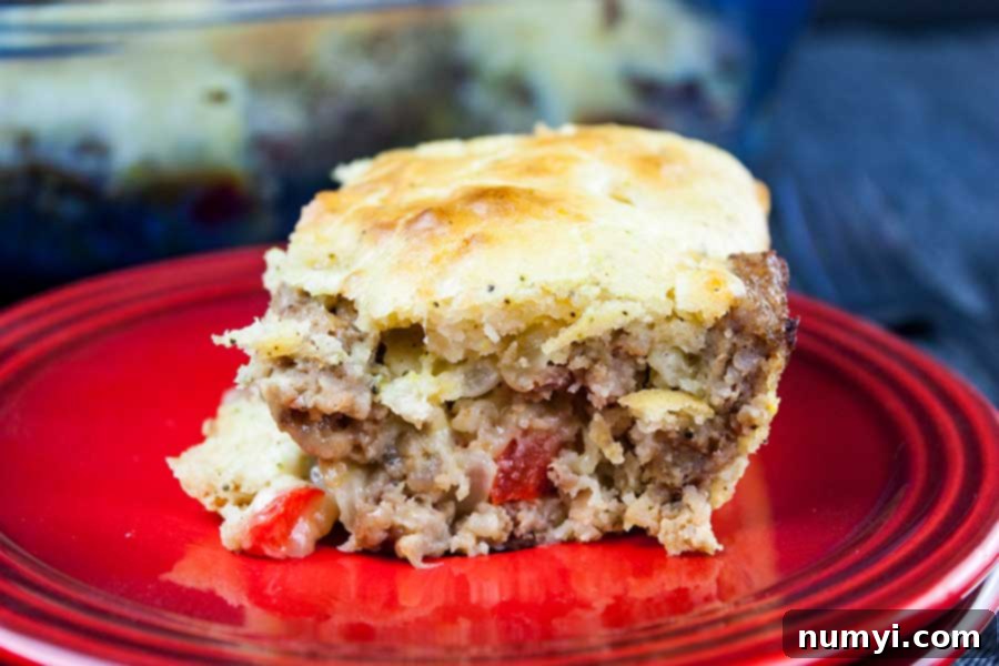 Hearty Sausage Breakfast Casserole 6 Another enticing view of a slice of the savory sausage breakfast cake, showcasing its rich textures and inviting golden crust on a red plate.