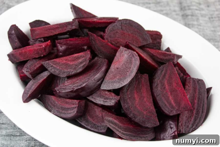 Beautifully sliced and piled pressure cooker beets displayed on an elegant white platter, ready to be served as a vibrant side dish.