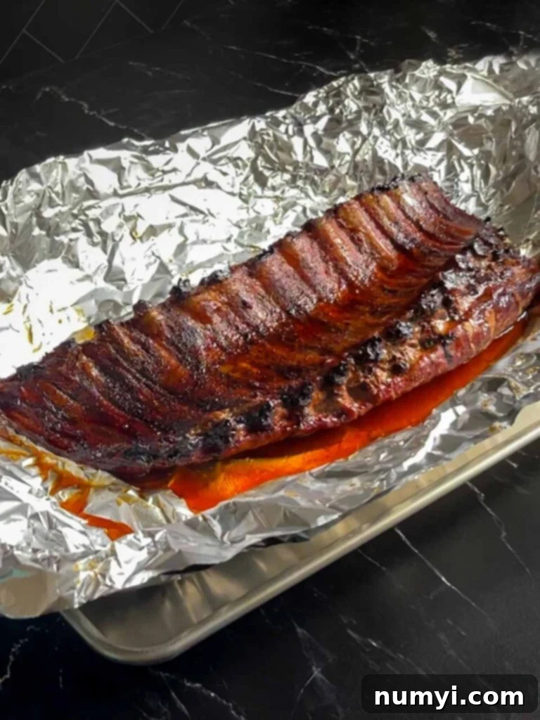 The Ultimate Smoked Baby Back Ribs 11 Baby back ribs coming out of the aluminum foil after cooking for an hour or so.