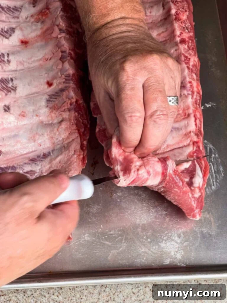 The Ultimate Smoked Baby Back Ribs 6 Trimming the ribs so little bits and pieces don't get burnt up in the smoking process.