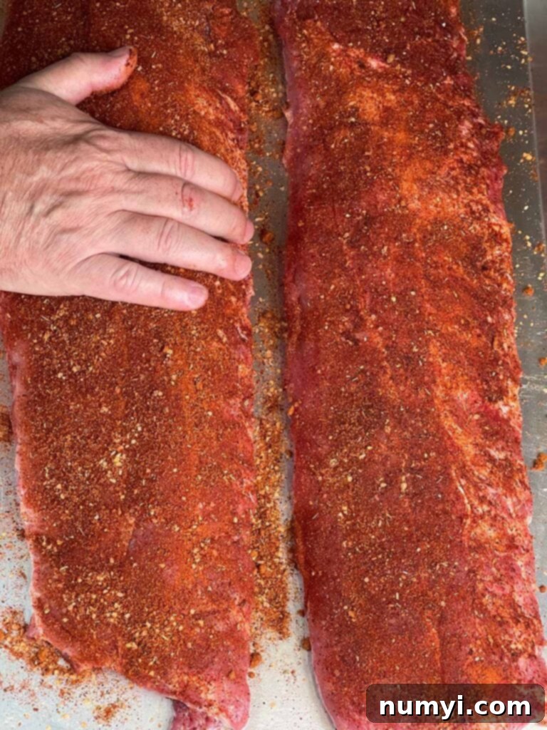 The Ultimate Smoked Baby Back Ribs 7 Applying the memphis style rub on baby back ribs.