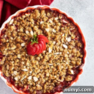 Overhead view of strawberry crisp fresh from the oven with a fresh strawberry fanned out on top for garnish.